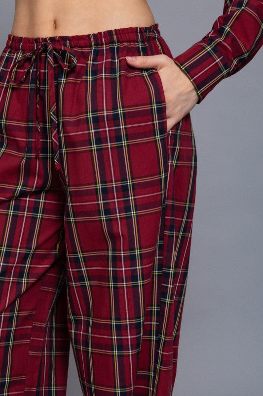 Red tartan plaid pants close-up showing the drawstring waistband and side pocket.