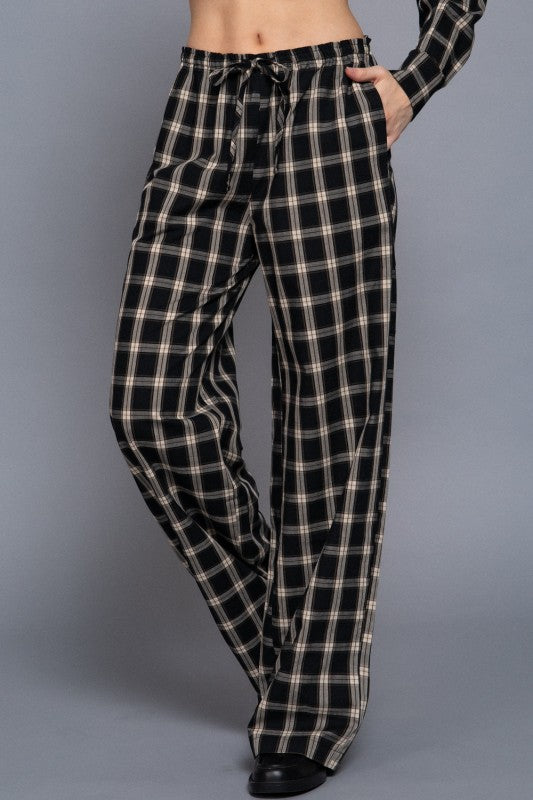 Black tartan plaid wide-leg pants showing the drawstring waist and side pocket, front view.