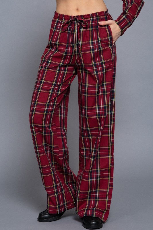Red tartan plaid wide-leg pants showing the drawstring waist and side pocket, front view.